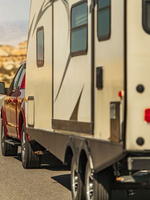 pickup truck pulling a travel trailer on a highway demonstrating how to tow a travel trailer